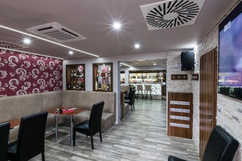 un restaurante con mesa y sillas y un bar en Penzion Škorpión, en Senec
