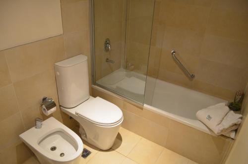 uma casa de banho com um WC, um chuveiro e um lavatório. em Hotel Finca Hermitage em Mendoza