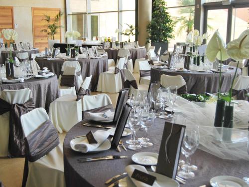 a banquet hall with tables and chairs with glasses and plates at Qgat Restaurant Events & Hotel in Sant Cugat del Vallès