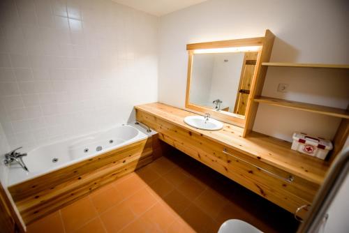 ein Badezimmer mit einer Badewanne, einem Waschbecken und einem Spiegel in der Unterkunft Casa Branca da Sociedade in Angra do Heroísmo