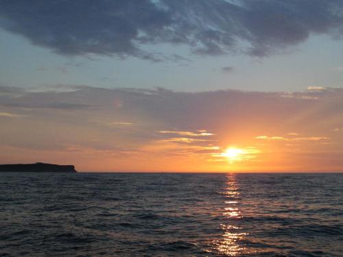 a sunset over the ocean with the sun setting at Berkshire B&B in Qimei