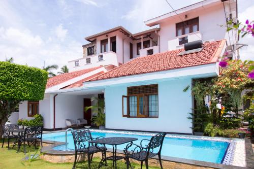 a villa with a swimming pool and a house at Suriya Arana in Negombo