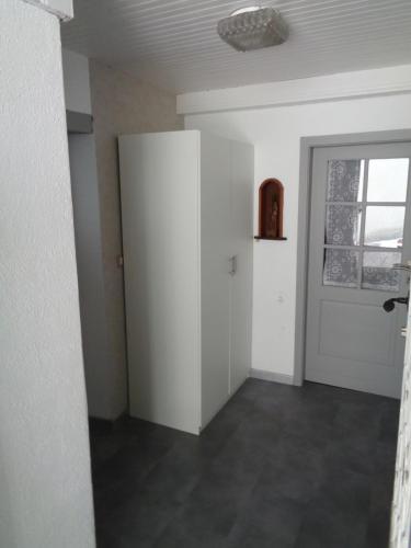 ein leeres Zimmer mit einer Tür und einem Fenster in der Unterkunft Studio Gite Fischer Ottrott in Ottrott