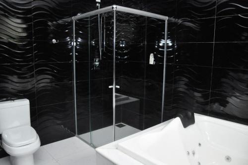 uma casa de banho com um WC e uma cabina de duche em vidro. em Rez Home Catas Altas em Catas Altas