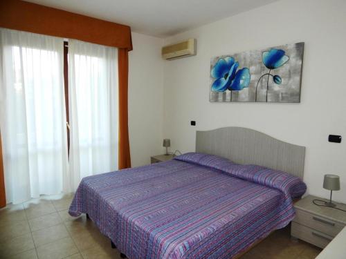1 dormitorio con 1 cama con manta morada en AffittaSardegna-TRILO GEMELLI 2 en Alguer