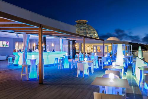 a restaurant with tables and chairs on a deck at night at Elba Premium Suites - Adults Only in Playa Blanca