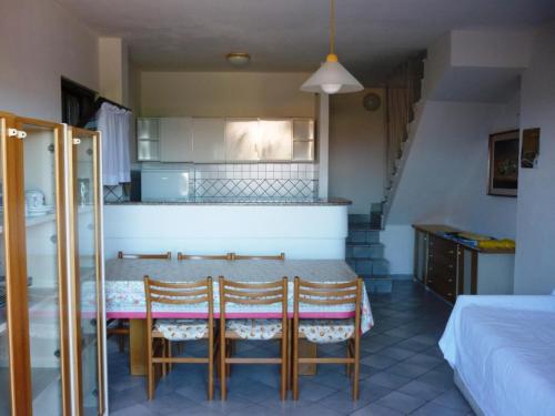 a kitchen with a table and chairs in a room at AffittaSardegna-Villetta Trilo Janna in Stintino