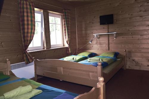 a bedroom with a bed in a log cabin at Penzion a restaurace Sokolí boudy in Dolní Malá Úpa