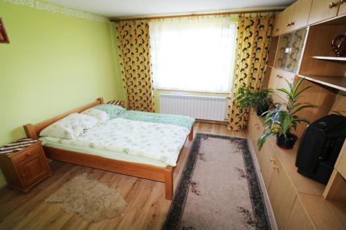 a small bedroom with a bed and a window at Agroturystyka Tyniok in Koniaków