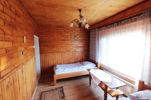 a small room with a bed and a window at Agroturystyka Tyniok in Koniaków