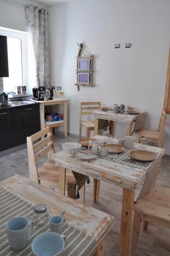 a kitchen with a wooden table and wooden chairs at B&B Les Chambres Rooms & Suite in Santa Teresa Gallura