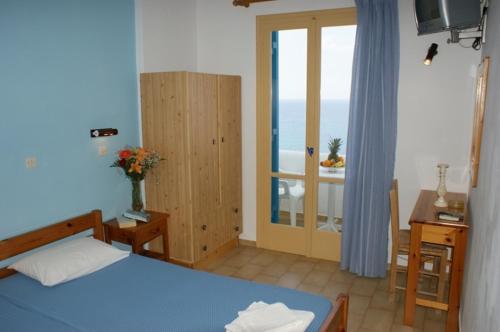 um quarto com uma cama e uma varanda com o oceano em Magic View em Naxos Chora