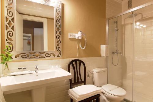 a bathroom with a sink and a toilet and a shower at Hostal Los Castañuelos in Candeleda