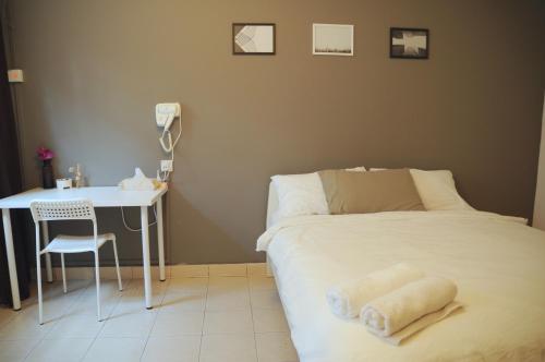 a bedroom with a bed and a desk and a table at GRAYHAUS Guest House in Petaling Jaya