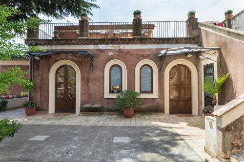an exterior view of a house with wooden doors at B&B Bellini in Milo