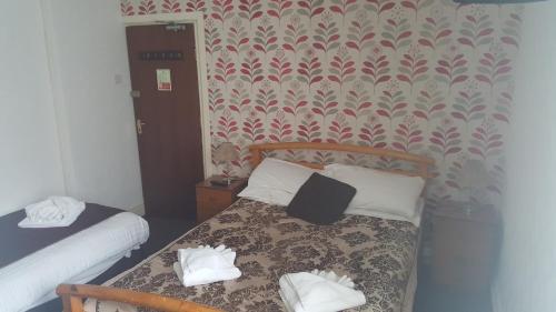 a bedroom with a bed with two towels on it at The Manuela Rose in Blackpool