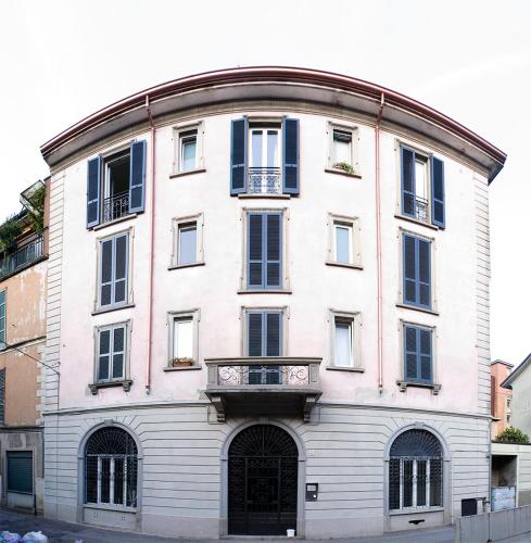 a large white building with blue windows and a balcony at SoloSonno in Lecco