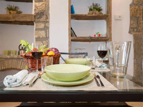 a table with a bowl and plates and wine glasses at La Torre del Prete in Civitella dʼAgliano