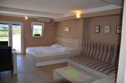 ein Schlafzimmer mit einem Bett und einer Couch in der Unterkunft Apartments Mango II in Baška