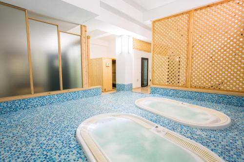 baño con bañera y azulejos azules en Hotel Mediterraneo, en Vieste
