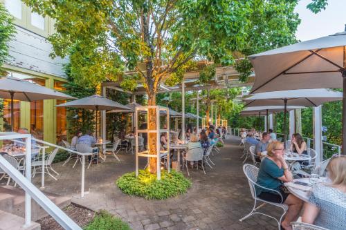 people sitting at tables under umbrellas at a restaurant at Proximity Hotel in Greensboro