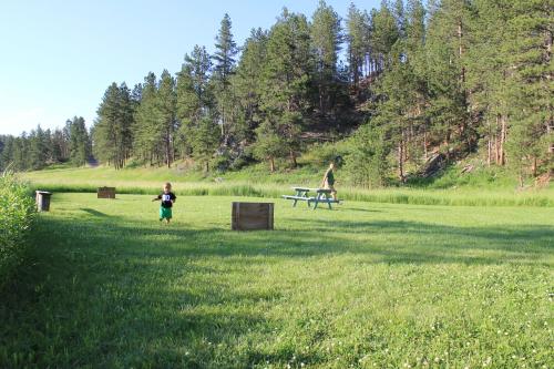 two people in a field with a picnic table at Black Elk Resort in Hill City