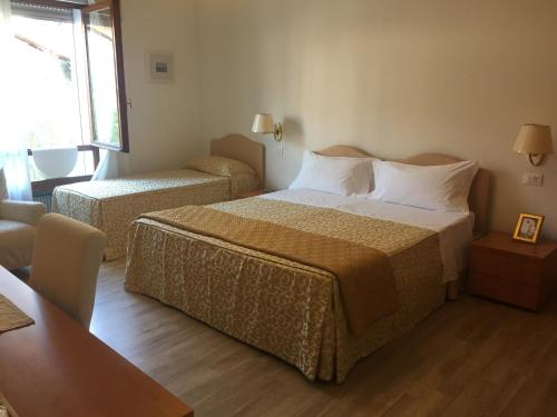 メストレにあるレジデンツァ ジャコムッツィのベッド2台とリビングルームが備わるホテルルームです。