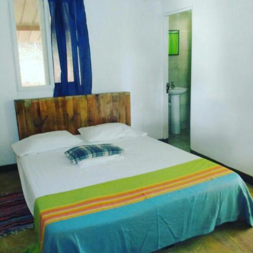 a bedroom with a bed with a wooden head board at Cebaco Sunrise Lodge in Isla Cebaco 