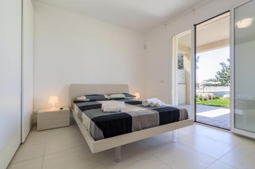 a bedroom with a bed and a sliding glass door at Il Giardino dei Frangipani in Santa Croce Camerina