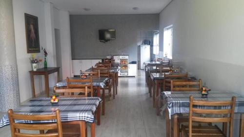 a dining room with tables and chairs in a restaurant at Avila Hotel in Boa Esperança