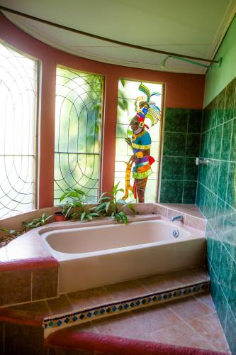 a bath tub in a bathroom with a stained glass window at Banana Bank Lodge & Jungle Horseback Adventures in Belmopan
