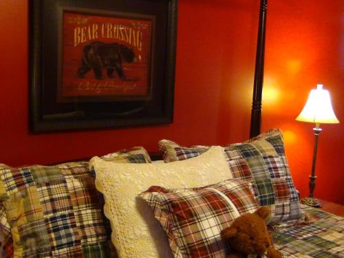 a teddy bear sitting on top of a bed with pillows at Berry Springs Lodge in Sevierville