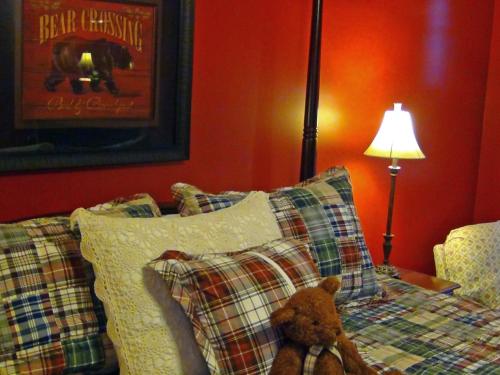 a teddy bear sitting on a bed with pillows at Berry Springs Lodge in Sevierville