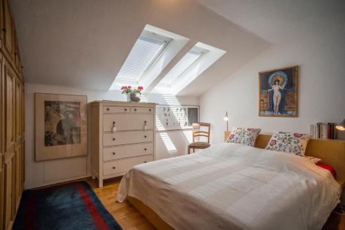 ein Schlafzimmer mit einem Bett und eine Kommode mit Fenstern in der Unterkunft Apartment Kaiserpanorama in Kiefersfelden