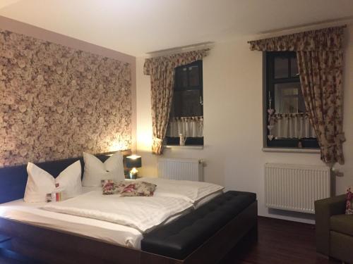 a bedroom with a bed and two windows at Hotel Trendtino in Eisenberg