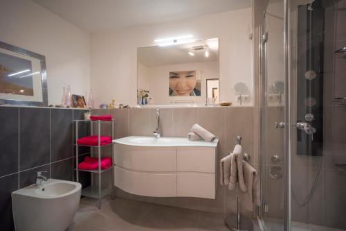 a bathroom with a sink and a shower with a mirror at Apartment Kaiserpanorama in Kiefersfelden