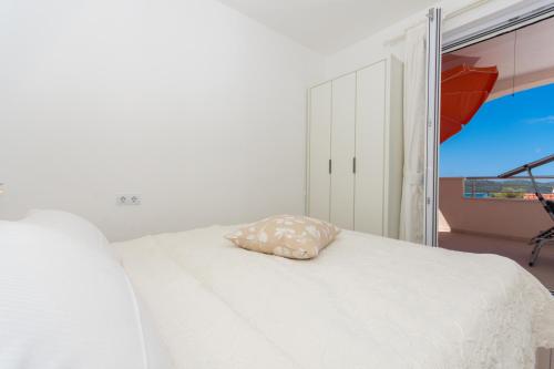 a bedroom with a white bed with a pillow on it at Villa Anastasia in Trogir