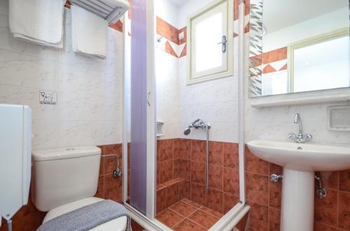 uma casa de banho com um chuveiro, um WC e um lavatório. em Windmill Naxos em Naxos Chora
