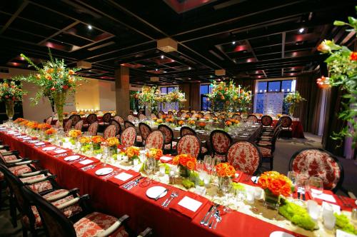 a long table with red tables and chairs with flowers at Proximity Hotel in Greensboro