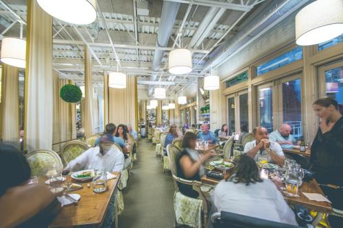a group of people sitting at tables in a restaurant at Proximity Hotel in Greensboro