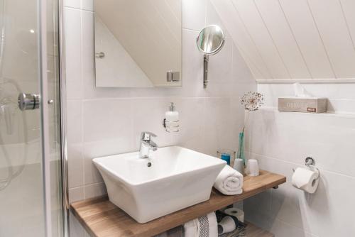 a white bathroom with a sink and a shower at Haus Ottenlock in Steinhude