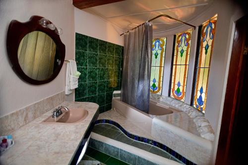a bathroom with a sink and a tub and a mirror at Banana Bank Lodge & Jungle Horseback Adventures in Belmopan
