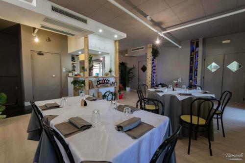 a group of tables in a room with white table cloth at Hotel Serena in Rieti