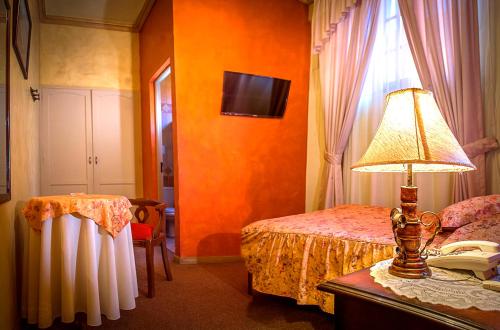 a bedroom with a bed and a lamp on a table at Hotel Monserrat in Cochabamba