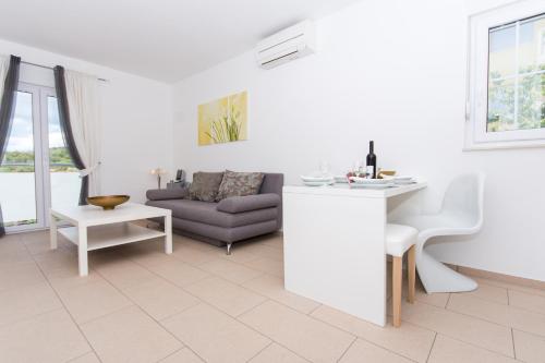 a white living room with a couch and a table at Villa Anastasia in Trogir