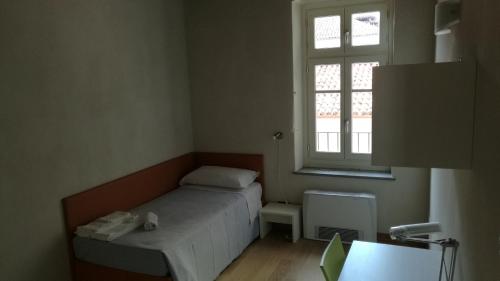 Una cama o camas en una habitación de Palazzo Sacco Hostello Fossano