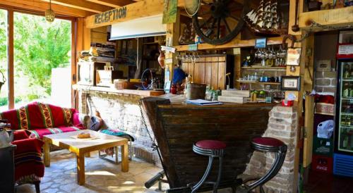 a bar with a couch and two stools in a room at Guesthouse Durmitor Magic in Žabljak