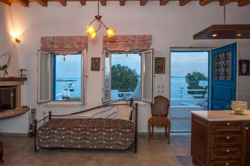 a bedroom with a bed and a desk and windows at Evita Apartments in Aliki