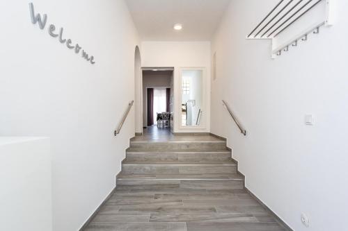 a staircase in a building with white walls and wooden floors at Villa Palma Krk in Krk