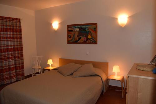 1 dormitorio con 1 cama y 2 luces en la pared en Casa da Praia | Luz Beach, en Luz